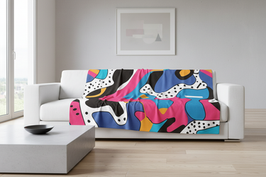 Blanket draped over white minimalist sofa