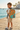 Boy in ivory tee on seaside promenade