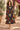 Brunette model wearing the floral midi dress in a Mediterranean villa courtyard