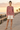 Brunette model wearing the knitted sweater on a boardwalk
