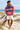 Curly-haired male model in a barefoot beach look with ivory shorts