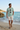 Dusty blue ODDSON tee on a Mediterranean beach