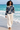 Female barefoot beach look with cream linen trousers