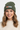 Female model close-up wearing cypress green beanie smiling
