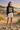 Female model in charcoal mountain graphic tee and ivory shorts