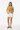 Female model in mustard tee with white denim shorts