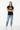 Female model in solid black tee with light wash denim jeans