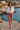 Female model styling the joggers with a tied white linen shirt