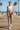 Female model styling the printed joggers with a white crop tank