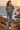 Female model wearing the military-green tee on a coastal cliff path