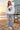 Female model wearing the white sweatshirt near a lifeguard tower
