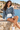 Female seated seaside look with denim shorts