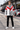 Front-facing model wearing the Sobori-Above Influence windbreaker in a motorsport setting