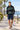 Geometric hoodie with navy boardshorts on a seaside promenade