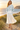 Golden-hour dunes look with an ivory pleated skirt