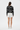 Full-length female model wearing the black botanical all-over-print sweatshirt with white tailored shorts on a white background, back view