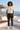 Joggers styled with a cream tee on a seaside rooftop