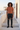 Joggers styled with a rust-orange tee in a Mediterranean village