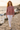 Knitted sweater styled with white jeans on a seaside path