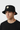 Male model close-up three-quarter view wearing black bucket hat