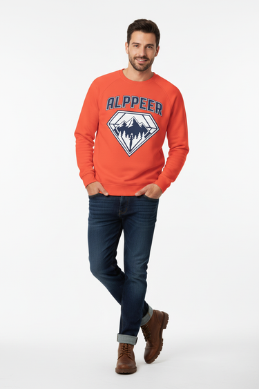Male model in burnt orange crewneck with dark denim jeans