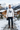 Male model in the white ODDSON hooded long-sleeve tee in an alpine ski village with snowy peaks