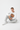 Male model in white sweatshirt with gray joggers sitting
