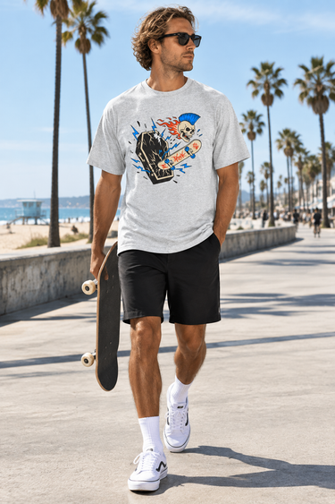 Male model wearing the ash skeleton skate tee on a beach boardwalk