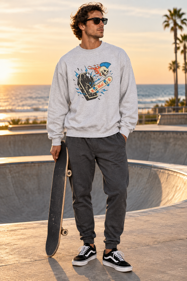 Male model wearing the ash sweatshirt beside a beachfront skate bowl