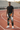 Male model wearing the patterned track pants on an athletics racetrack
