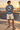Male model wearing the steel-blue tee beside a beachfront skate bowl