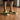 Man wearing yellow and black slip-ons with black shorts on wooden floor