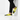 Man wearing yellow and black slip-ons with track pants against wall
