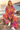 Matching tie-dye hoodie and wide-leg joggers, seated seaside