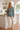 Model having kitchen coffee in the palm-print pajama top