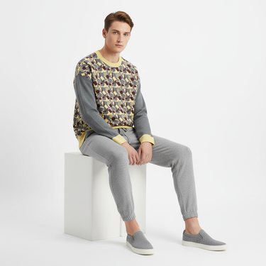 Model in sweater with gray joggers and slip-ons