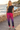 Model wearing tropical joggers on a coastal boardwalk