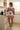 Petal Love hoodie styled with blush shorts in a sunlit kitchen