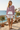 Pink hoodie styled with white linen shorts and tan sandals