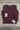 Solid burgundy sweater back folded on oak