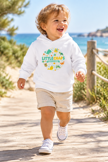 Two-year-old in white hoodie on a beach boardwalk
