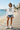 White hoodie with jean shorts on a coastal boardwalk