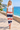 White tee and striped joggers on a coastal promenade