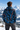 Back view: male model at mountain overlook, facing away
