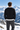 Back view: male model at mountain overlook, facing away