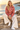 Blonde model seated seaside in cream linen trousers