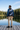 Blue quarter-zip rear view beside an alpine lake