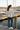 Camo sweater with charcoal trousers, rear-angle harbor look