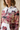 Close-up editorial of the hoodie’s neckline and rose-print sleeve