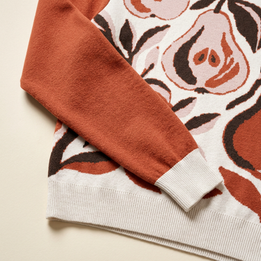Close-up of the rust sleeve and cream ribbed trim